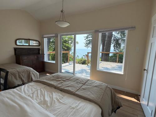 a bedroom with two beds and a view of the ocean at Cedar House Ocean View & Access in Roberts Creek