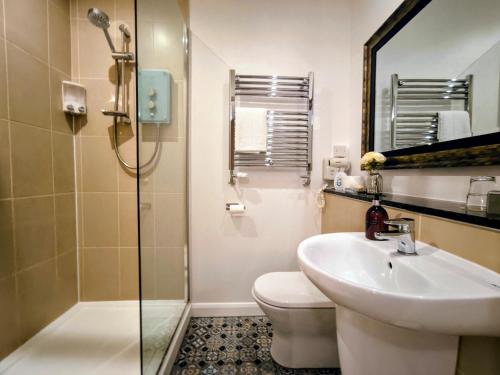 a bathroom with a sink and a toilet and a mirror at The Churchill Court in Woodstock