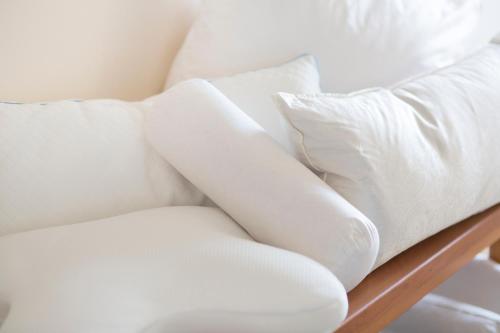 a white couch with white pillows on it at Stadthotel Crailsheim in Crailsheim