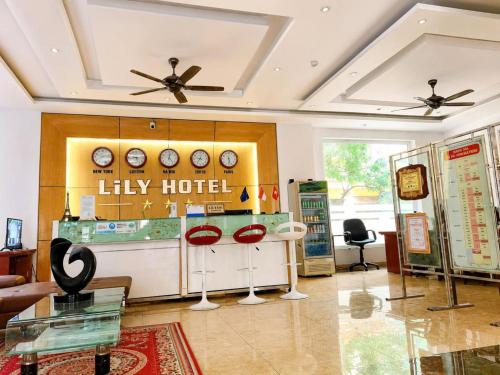 a living room with a lobby with clocks on the wall at LiLy Hotel Ninh Bình in Ninh Binh