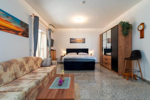 a living room with a couch and a bed at Monte Mare in Donji Seget