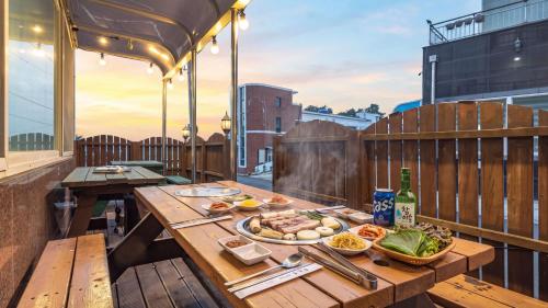 a table with a plate of food on a balcony at Geoje Blueberry Pet Pension in Geoje