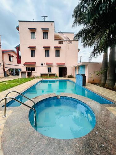 a swimming pool in front of a building at Breezevalley Residency in Yelagiri