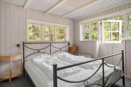 a bed in a room with two windows at 0140-Romo-Kap-Farvel-7 in Høm