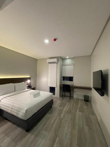 a bedroom with a bed and a flat screen tv at Mango Suites - Angeles in Angeles