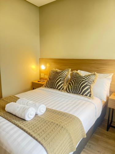a bedroom with a large bed with towels on it at Mango Suites - Angeles in Angeles