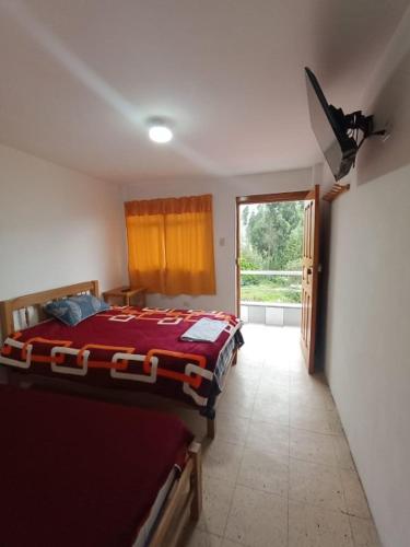 a bedroom with a bed and a sliding glass door at Hospedaje Hacienda Norabuena in Recuay