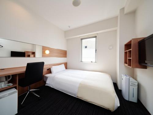 a hotel room with a bed and a desk at Super Hotel Namba Nipponbashi in Osaka