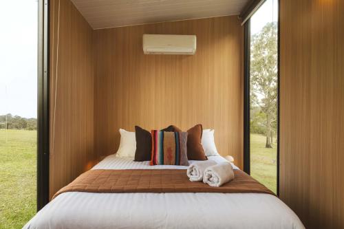 a bedroom with a large bed with a large window at Two-Ki by Tiny Away in Rainbow Flat