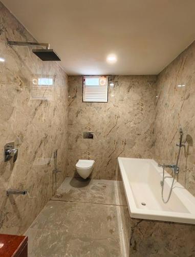 a bathroom with a tub and a toilet and a sink at Hotel SS Palace in Gaya