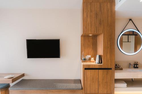 a living room with a television on a wall at Pamookkoo in Kata Beach