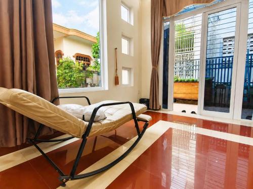 a room with a chair in front of a window at The Mellow House Nhật Lệ in Dong Hoi