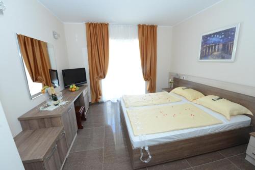 - une chambre avec un grand lit et une télévision dans l'établissement Sobe Milo, à Veliko Gradište