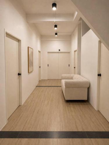 a room with a couch and a hallway with doors at 9 mins to BTS Queen Bed Private Room - Share Bath in Amphoe Phra Khanong
