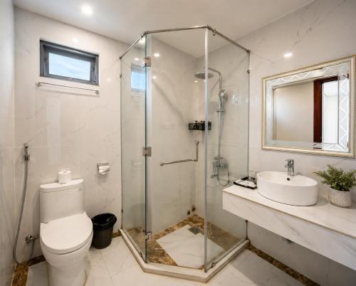 a bathroom with a shower and a toilet and a sink at Le Centre Pleiku Hotel in Pleiku