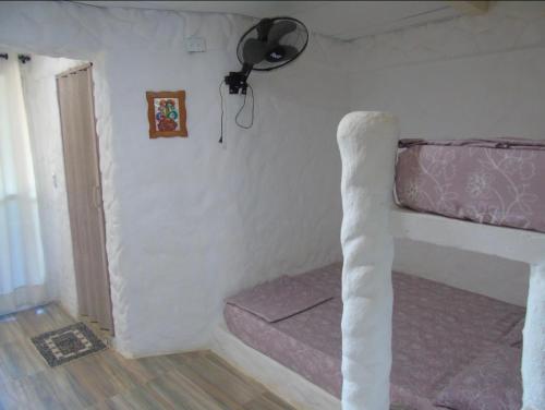 a bed in a room with a ceiling fan at brisas costeña in Santa Marta