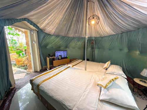 a bedroom with a bed with a canopy at Chevilly Resort & Camp in Bogor