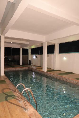 a large swimming pool in a hotel room at Maison Madame - Female only Shared Apartment Lekki in Lekki