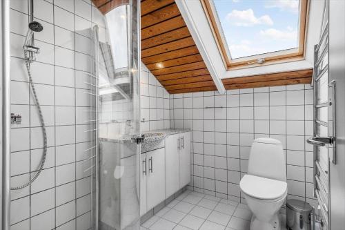 a bathroom with a toilet and a shower and a window at 0658-Toftlund-Ostmarken-56 in Toftlund