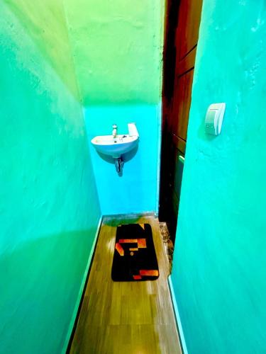 a bathroom with a sink in a blue wall at Novena bungalow Oeseli in Pulau Helihana