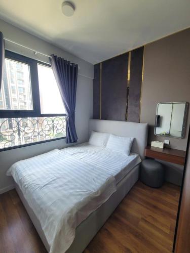 a bedroom with a large bed and a window at Căn Hộ Cao Cấp Cara River Park in Cái Răng