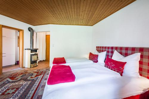 シュヴァーツにあるFerienwohnungen Vomperbergのベッドルーム(赤い枕の大きな白いベッド付)
