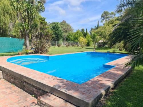 a swimming pool with a brick retaining wall around it at El Campito in Abasto