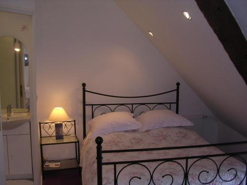 a bedroom with a black bed with white pillows at Chambre d'hôte Priory-View Dinan in Dinan