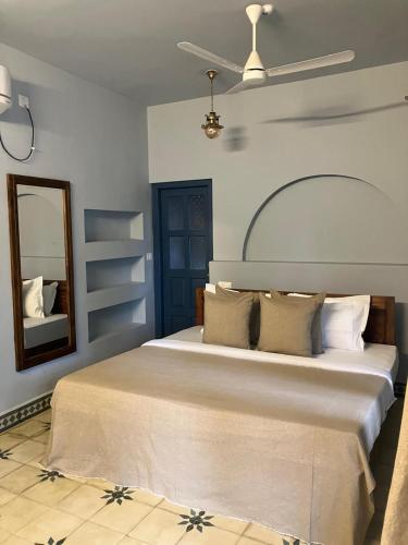 a bedroom with a large bed and a mirror at Aali villas in Mararikulam