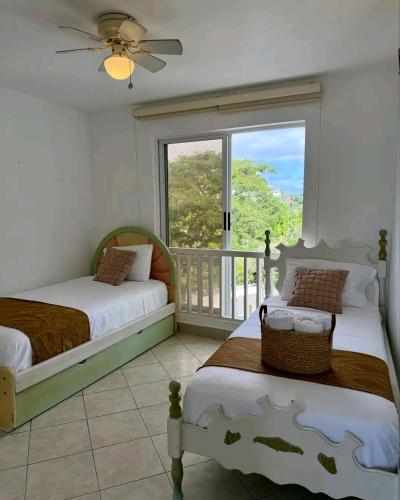 a bedroom with two beds and a balcony at Exclusivo Departamento playa in Same