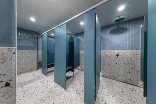 a bathroom with blue walls and tile floors at Bounce Surfers in Gold Coast