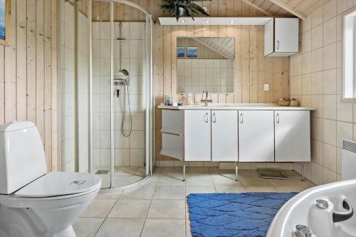 a bathroom with a shower and a toilet and a sink at 7323-Bogo-Vindrosen-23 in Gammelby