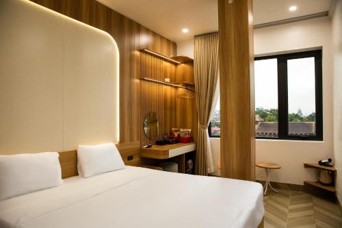 a bedroom with a white bed and a window at Trang An Harmony Hotel in Ninh Binh
