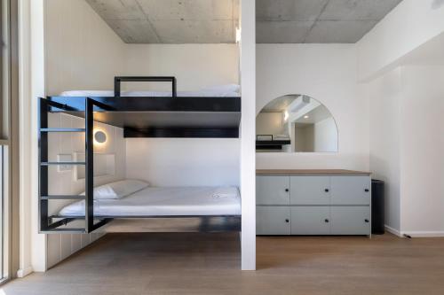 two bunk beds in a room with a mirror at Bounce Surfers in Gold Coast