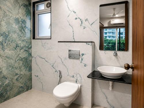 a bathroom with a toilet and a sink at ASPA Apartments in Navi Mumbai