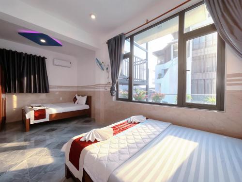 a bedroom with two beds and a large window at Mimosa 8 Hotel - Ninh Chử in Ninh Hải