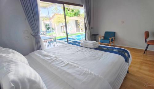 a bedroom with a large bed and a large window at บ้านออมPool villa บางแสน sin in Ban Bang Saen (1)