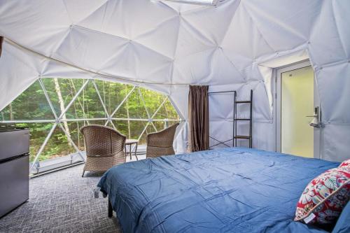 a bedroom with a bed in a tent at Pleasant River Glamping Dome 3 King bed in Bethel