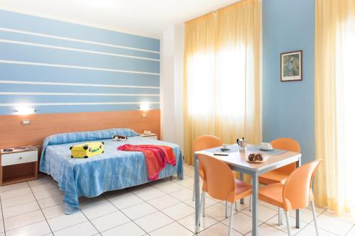 una camera con letto, tavolo e sedie di Welcome Residence per famiglie a Rimini
