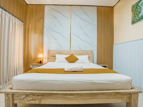 a bedroom with a large bed with a wooden headboard at Pondok Lulik Homestay Canggu in Canggu