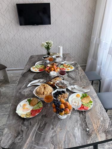 a table with many plates of food on it at Rest House in Bokonbayevo