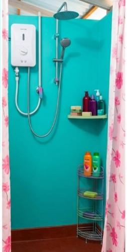 a bathroom with a shower with a blue wall at SunBeachHouse in Weligama