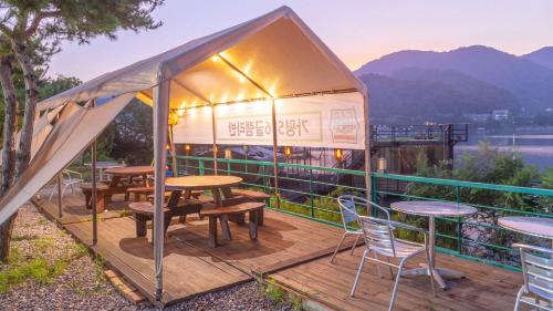a gazebo with tables and chairs on a deck at Gapyeong 516geullaemlaban in Gapyeong