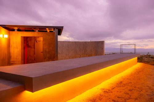 a building with yellow lights on the side of it at Yunagi 夕凪プライベートサウナ付ヴィラオーシャンフロントの絶景宿 夕日とサウナを満喫海と夕日に包まれる贅沢空間 in Mōrai