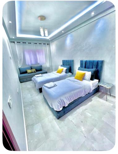 a bedroom with two beds and a couch at Oasis Gueliz Center Marrakech in Marrakesh
