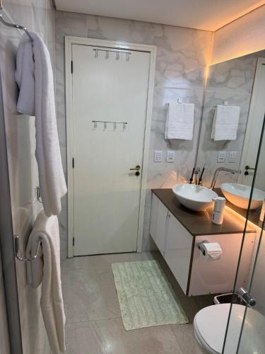 a bathroom with a toilet and a sink and a door at Sítio Paradouro in Novo Hamburgo