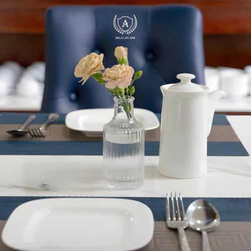 a vase of water with flowers in it on a table at Sala Lan Anh hotel in Phước Long