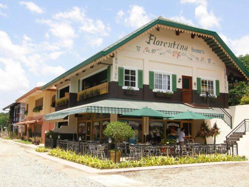 a building with tables and chairs in front of it at Florentina Homes in Dumaguete