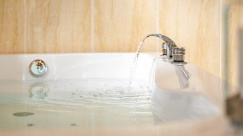 a white bath tub with a water fountain at Gapyeong Arom Spa Pension in Gapyeong