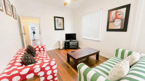a living room with two couches and a table at Teke Cottage in Wooli
